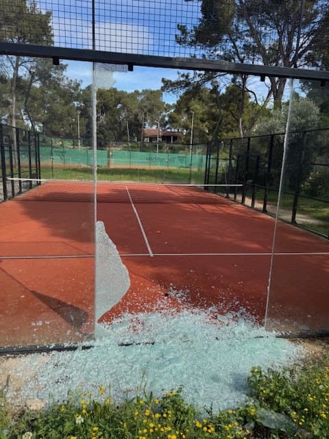 Avant : vitre de padel explosée, éclats de verre au sol sur le terrain
