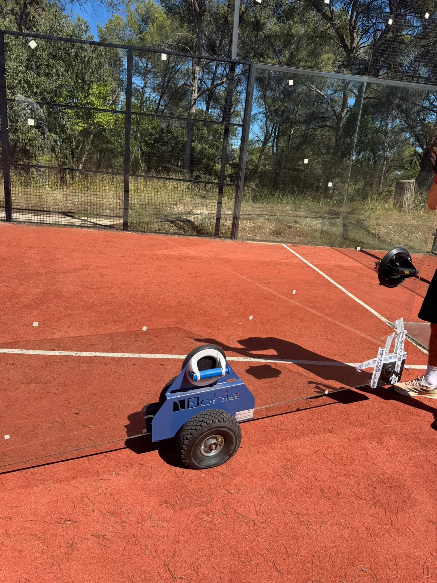 Machine de nettoyage professionnelle bleue utilisée sur un court de padel
